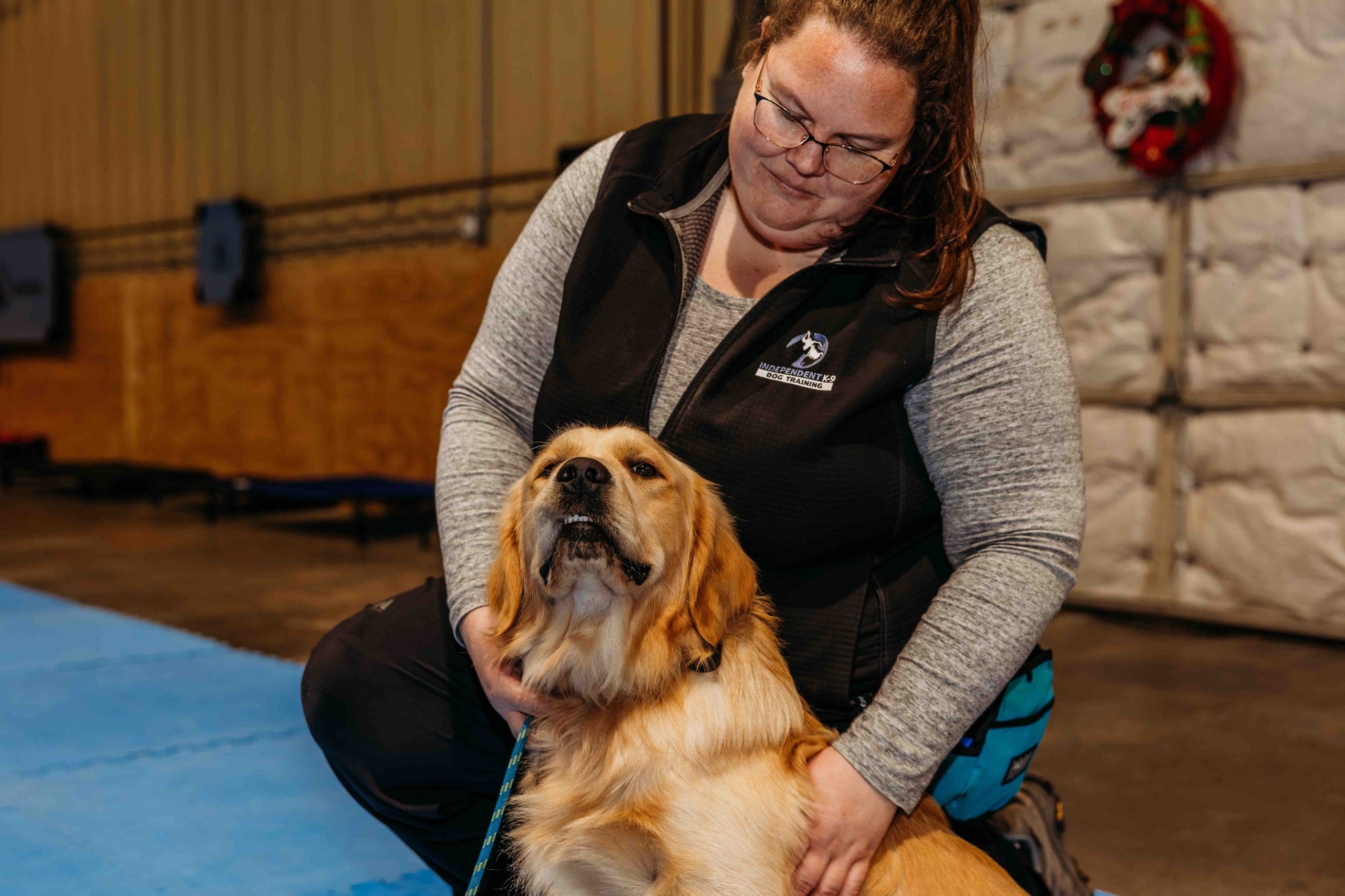 Jess sitting with a smiling Golden Retriever at Independent K-9