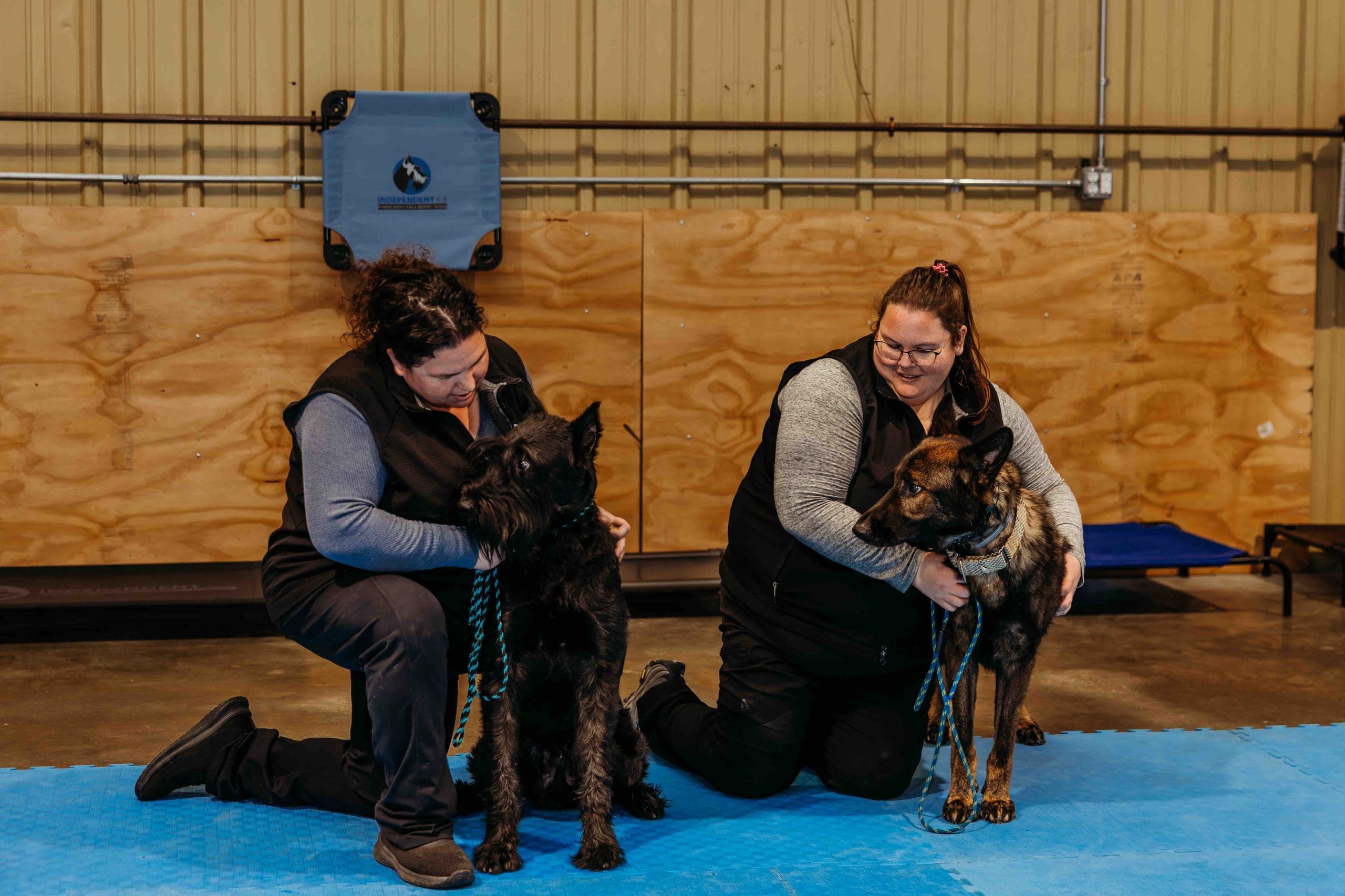 The Independent K-9 training team kneeling with their German Shepherds at their Martinsburg facility